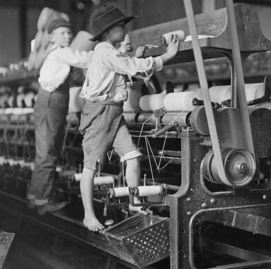 Children working on textile mill powered by a flat leather belt.